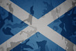 flag of scotland on the khaki texture . military concept