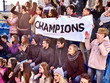 © Gennadiy Poznyakov - Fans cheering in stadium holding champion banner and singing on tribunes. Large group young people together support your favorite team.