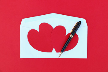 Poster - two red paper hearts on white envelope and black business pen