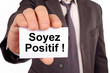 © Richard Villalon - Homme tenant une carte avec soyez positif écrit dessus