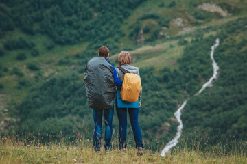 Man and woman standing and hugging on the top of the mountain, a