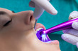 © karelnoppe - Dentist setting fissure sealant with led curing lamp on patient.