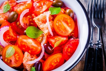 Wall Mural - panzanella: Italian salad with tomatoes, ciabatta bread, olives, red onion and basil closeup