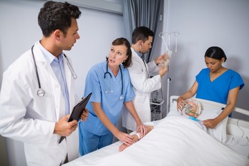 Canvas Print - Doctors examining senior patient 