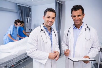 Canvas Print - Portrait of two doctors standing with medical report