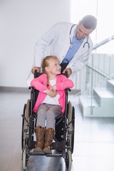 Wall Mural - Doctor pushing girl in wheelchair 