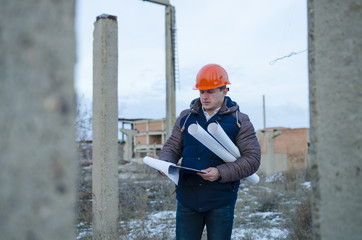 The man worker wear a orange helmet with construction site