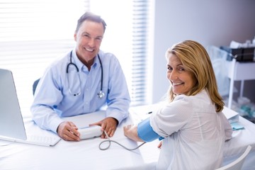 Wall Mural - Doctor checking blood pressure of a patient