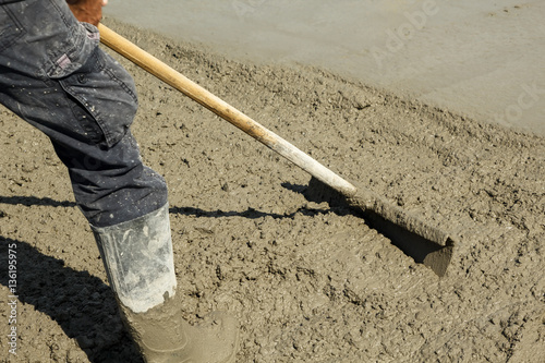 Fotografie, Obraz Spreading out freshly poured concrete with a shovel