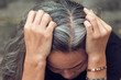 woman and gray hair with worried stressed face looking down