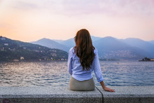 Young woman admiring sunset at the lake Como