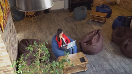Aufkleber - Emptyin startup company only one woman sitting in casual office calling client and checking information in computer. Asian young female wearing in stylish red cardigan has phone conversation use