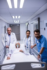 Wall Mural - Doctor and nurse pushing emergency stretcher bed in corridor