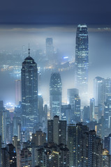 Misty night view of Victoria harbor in Hong Kong city