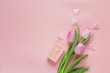 Romantic background with tulips and gift box on pink. Space for
