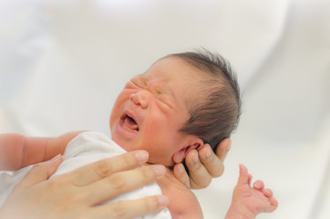 newborn asian baby crying on white background