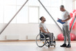 © zinkevych - Smiling young disabled patient having conversation with his physical therapist