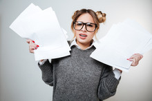 Irritated Frowning Young Woman In Glasses Standing And Holding Documents