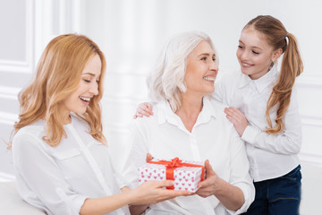 Poster - Joyful family members holdign present