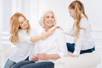 Wall Mural - Positive mother and little daughter resting with grandmother