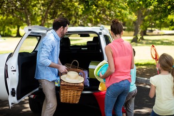 Wall Mural - Family placing picnic items in car trunk