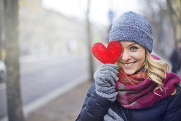 Girl covering her eye with heart