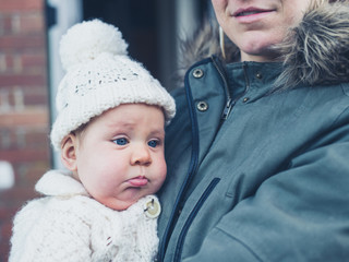 Wall Mural - Mother with baby outside house in winter