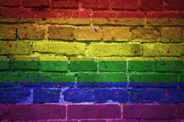 painted gay pride rainbow flag on a brick wall