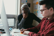 © ZeroThree - Two men working togehter in a small home office.