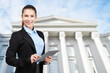 Law and justice concept. Young woman with tablet on courthouse background