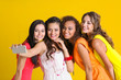 © Africa Studio - Beautiful girls taking selfie on yellow wall background