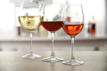 Poster - Three glasses with wine on kitchen table