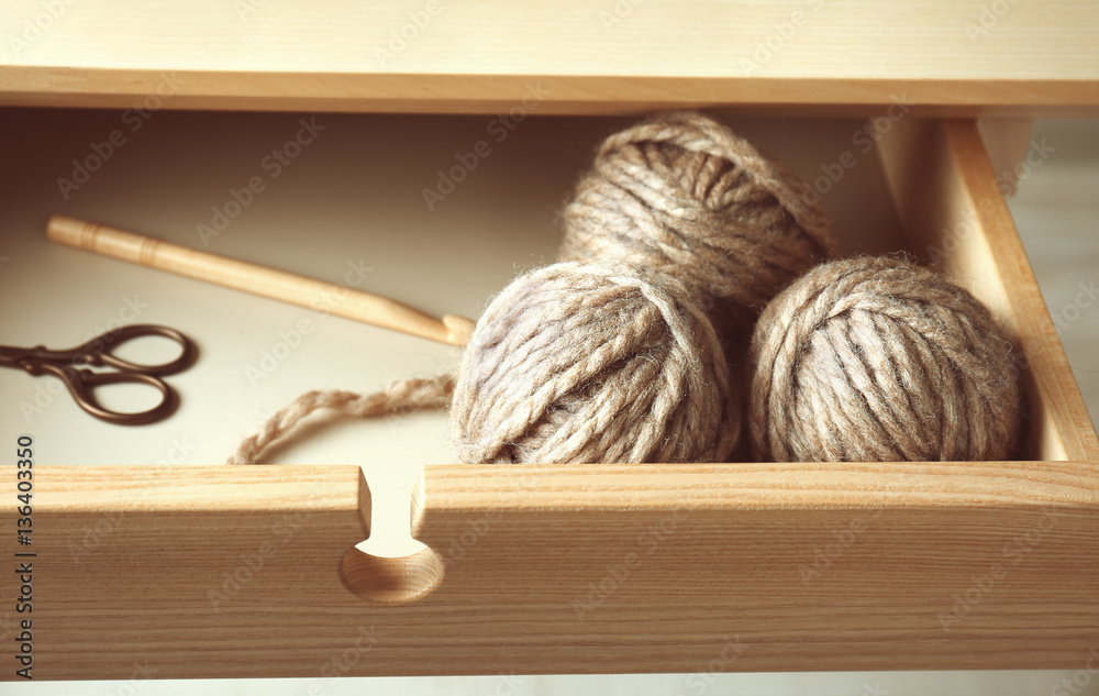 Balls of knitting yarn in table drawer