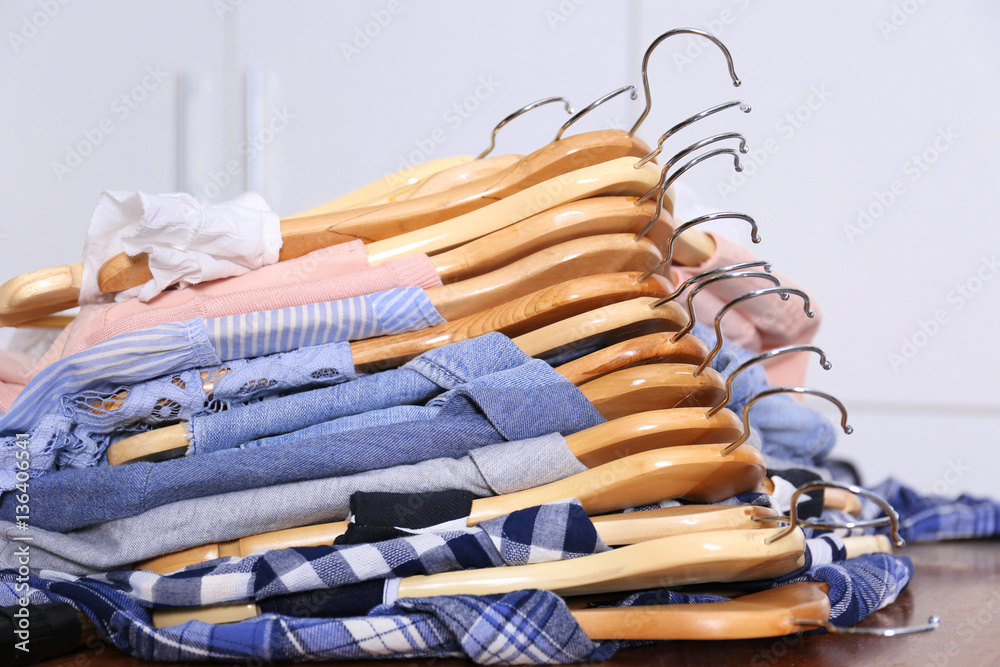 Closeup of hangers with different clothes on table