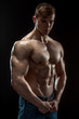 © nazarovsergey - Young bodybuilder man on black background