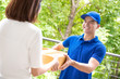 © Atstock Productions - Delivery man in blue uniform delivering parcel box to a woman