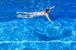 © R - Woman in a bikini floating in swimming pool