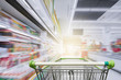 © nonnie192 - Supermarket aisle with empty green shopping cart