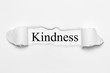 Kindness on white torn paper