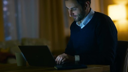 Aufkleber - Middle Aged Man Sitting at His Desk Working on a Laptop. He's Satisfied. He Smiles.In the Background His Apartment in Yellow Tones with a Skyscrapers View. Shot on RED EPIC-W 8K Helium Cinema Camera.