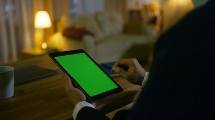Aufkleber - At Home Man Sits at His Desk and Uses Tablet Computer with Green Screen on it. His Apartment is Done in Yellow colours and is Warm. Shot on RED EPIC-W 8K Helium Cinema Camera.