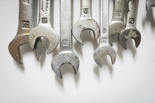 Close-up Of Wrenches Hanging On White Wall At Workshop