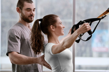 Rehabilitation concept. Young woman doing exercises under physiotherapist supervision