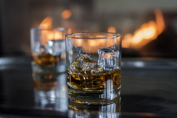 Two Scotch on the rocks cocktails by the fire