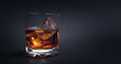 Whiskey with ice cubes on dark background