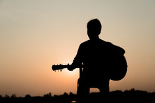 Silhouette Of Man Playing Guitar At Sunset