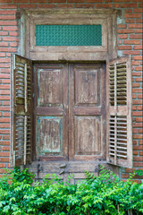 Ancient wooden window vintage and green tree on the brick wall