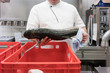 Koch in Restaurant Küche prüft Lieferung von Fisch