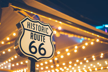 Historic Route 66 Sign In California With Decoration Lights On The Background