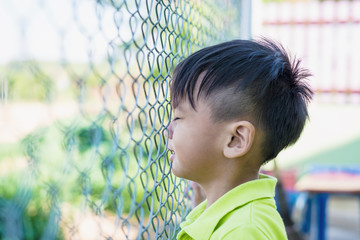 Image of sad boy,cage or prison with no freedom concept